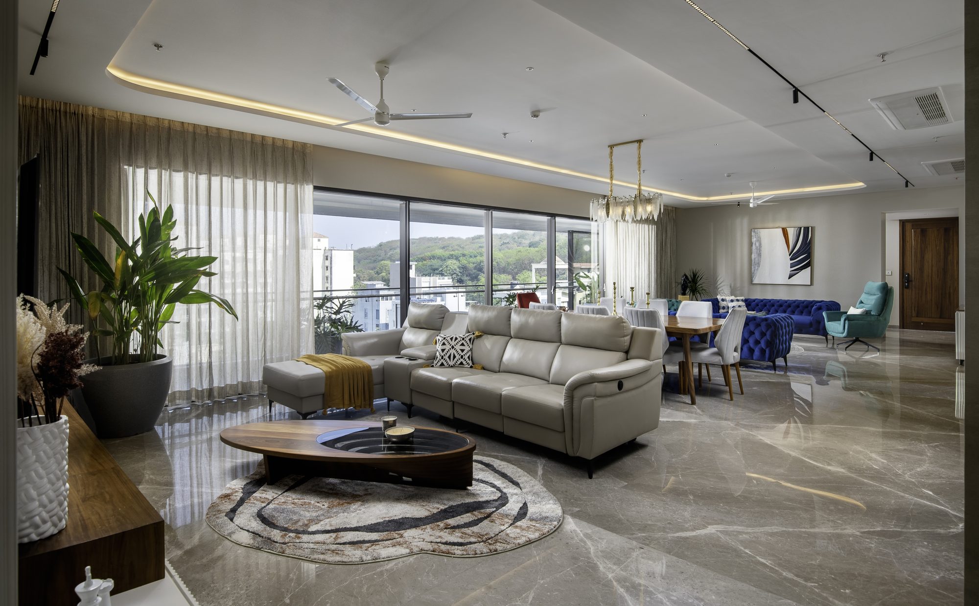 The living and dining areas of an Attalika residence, opening to a full-height window wall