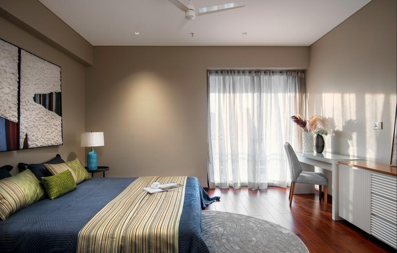 A bedroom in an Attalika residence, opening to the balcony and the skyline beyond