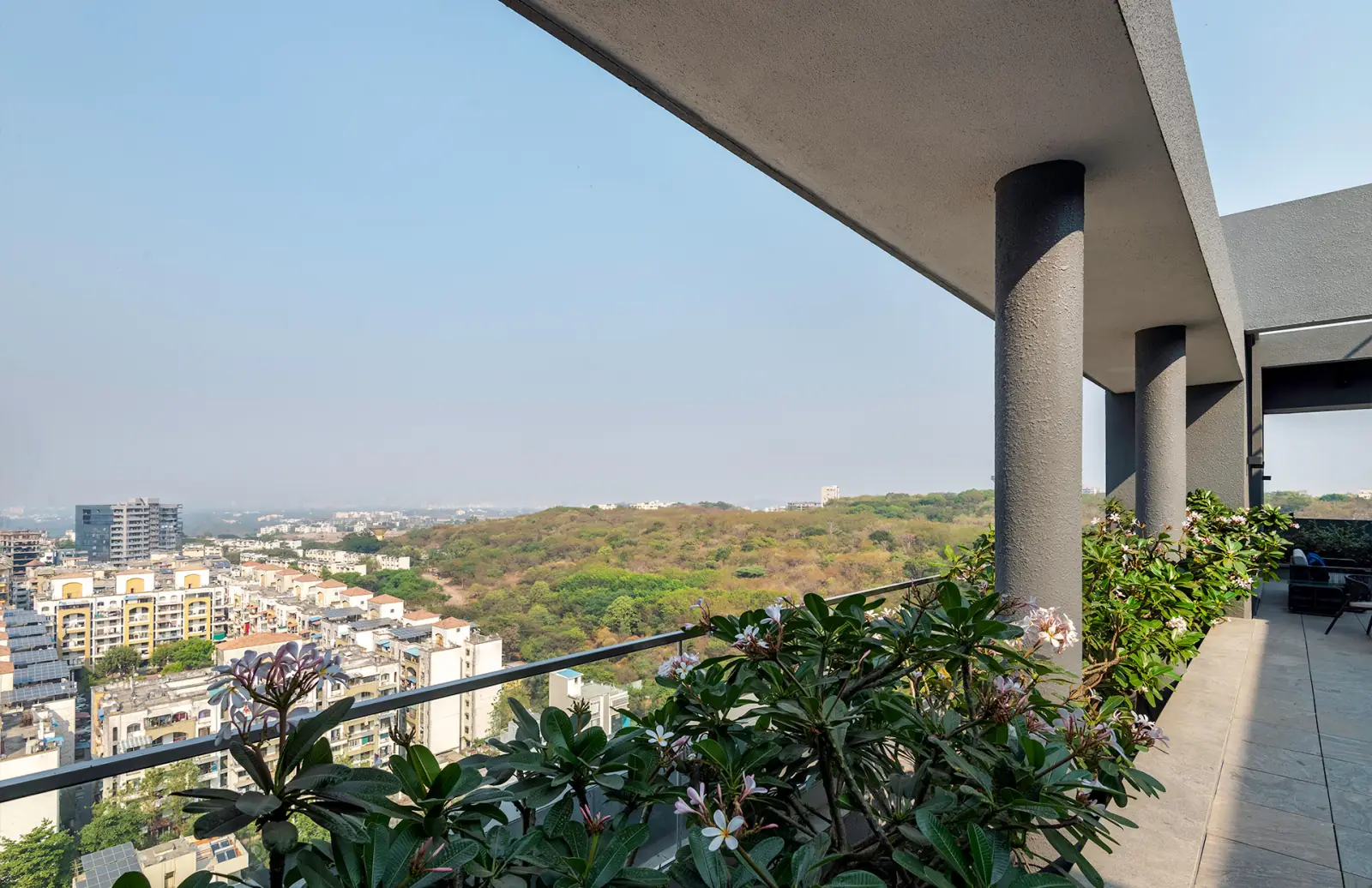 The view from a balcony across landscaped surroundings toward the hills