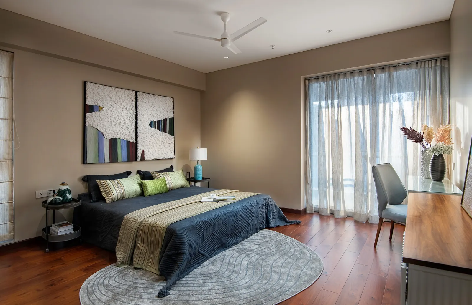 The master bedroom, with framed artwork above the bed and a dresser by the window