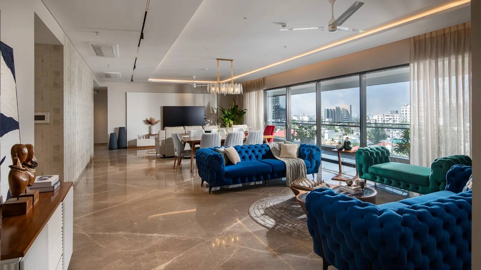 The formal living room, with tufted sofas and a dining table beyond