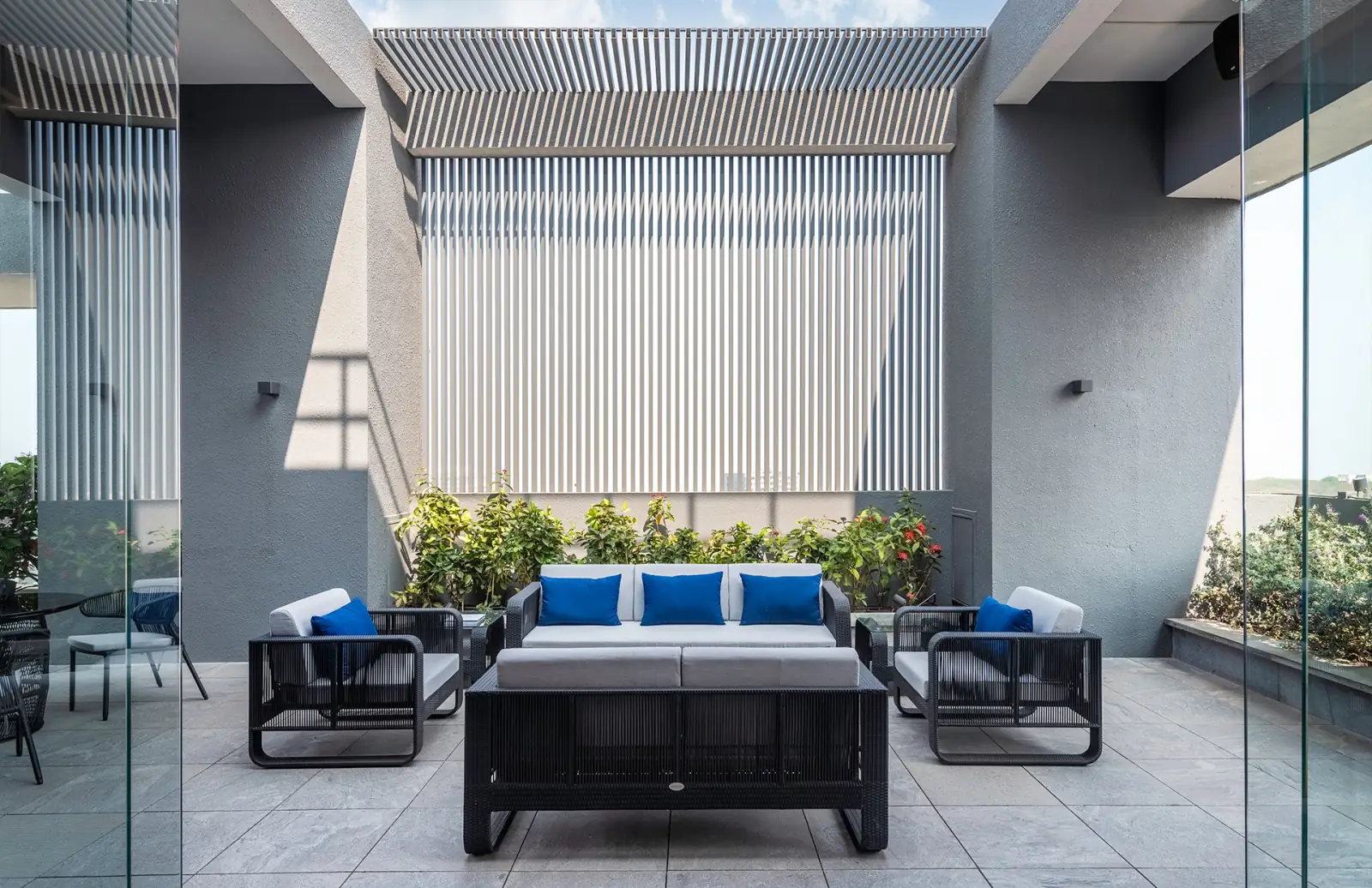 Outdoor lounge seating on the rooftop terrace, under a shaded pergola